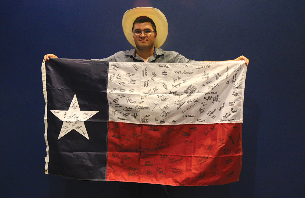 Timothy Holub shows off his Texas flag, signed by all the 2018 Texas Youth Tour participants and chaperones